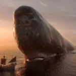 Laboon, the colossal whale with Luffy's Straw Hat Jolly Roger painted on his forehead, rises from the sea beside the Going Merry at sunset in One Piece live-action Season 2 Episode 2, "Good Whale Hunting."