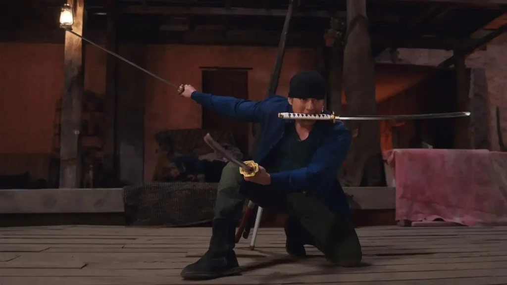Zoro in dark clothing performs a dramatic katana stance during a tense battle scene from Netflix’s One Piece Live Action Season 2 Episode 3 “Whisky Business.”