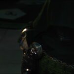 Dr. Doom stands in a ruined landscape as green light glows through the scene.