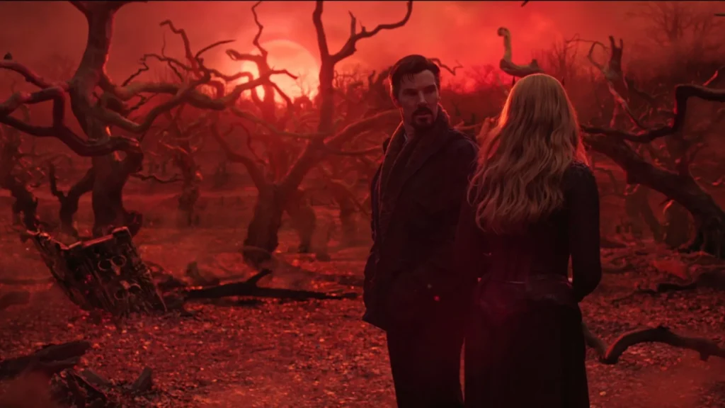 Doctor Strange standing with Wanda Maximoff in a eerie, red-lit field of bare, twisted trees.
