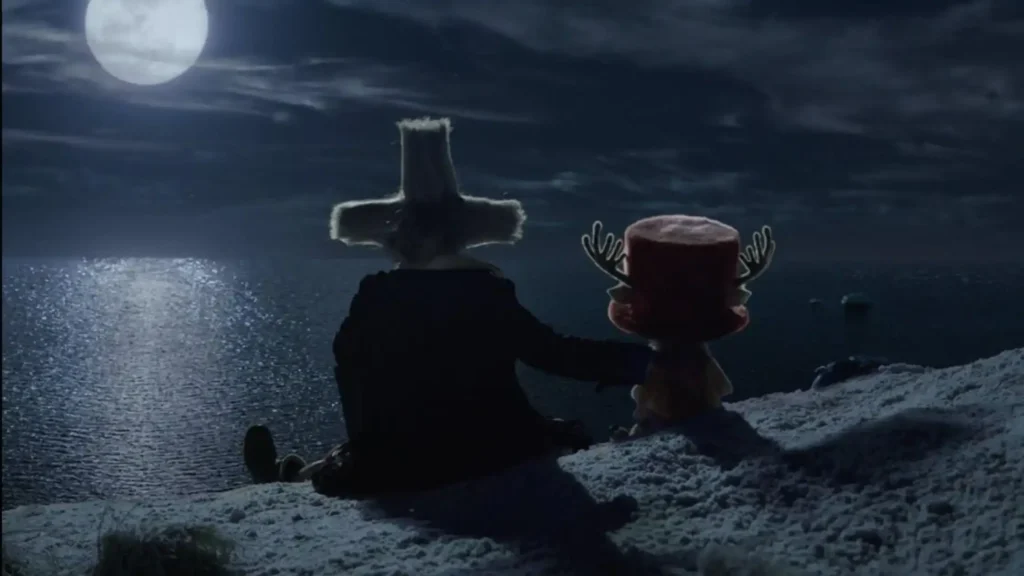 Tony Tony Chopper and Dr. Hiriluk sit together on a snowy cliff under a full moon, overlooking the ocean in Netflix's One Piece Season 2 Episode 7, "Reindeer Shames."