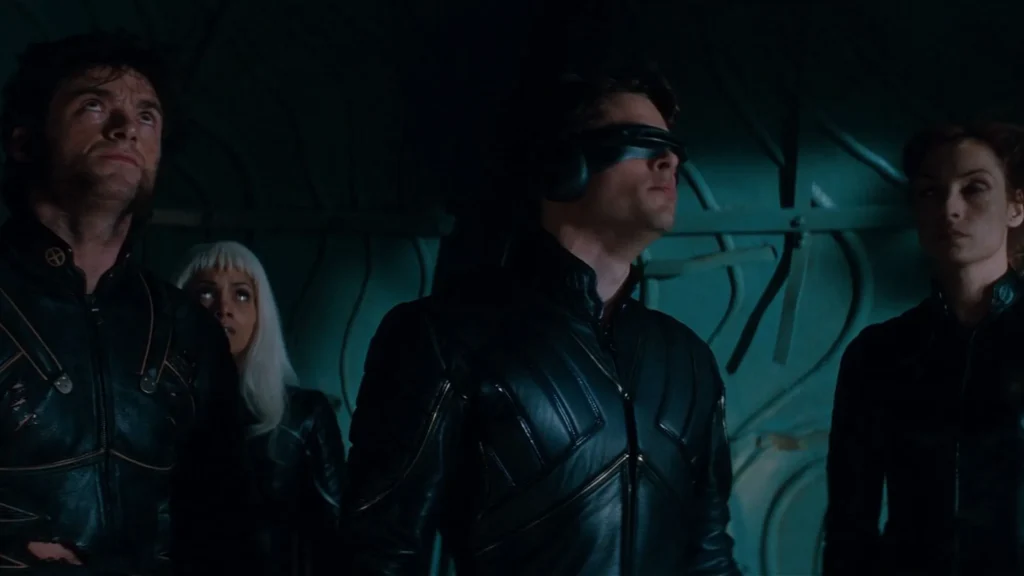 Wolverine, Storm, Cyclops, and Jean Grey wearing black leather suits looking upward inside Cerebro in Fox's X-Men.
